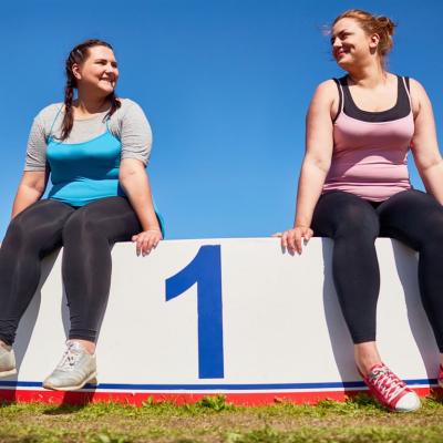 Dos mujeres después de hacer ejercicio sentadas en un podium